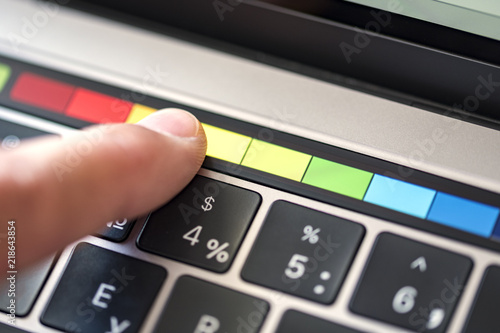 The finger selects the color on the touchbar panel photo