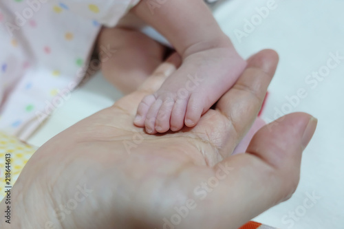 One hand holding foot of newborn