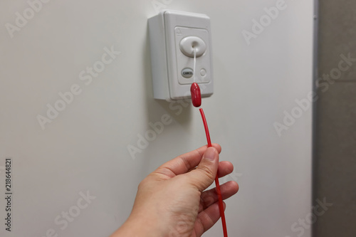Pulling of red emergency call alert in the hospital toilet