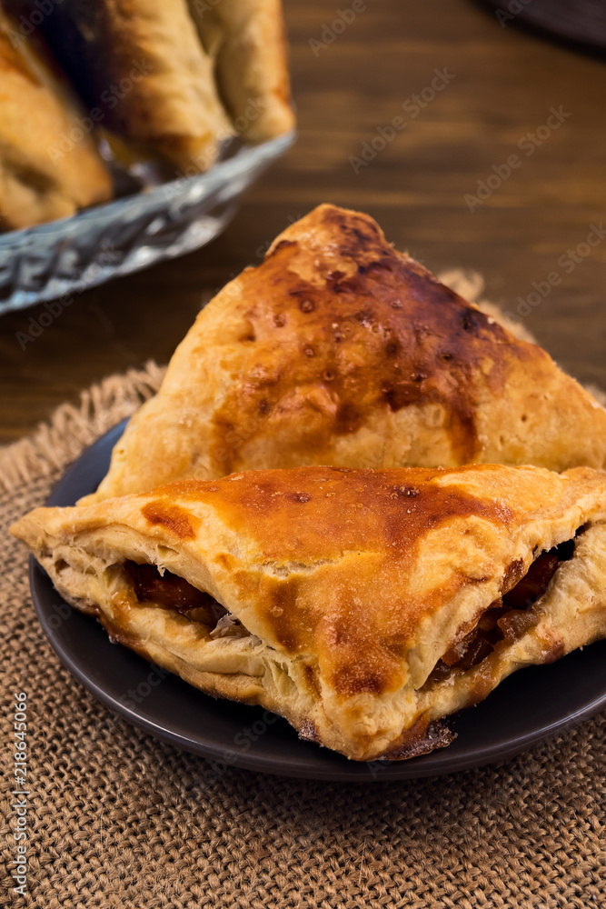Puff pastry with Apple filling close-up, vertical frame on wooden background. Puff pastry with Apple filling close-up, vertical frame on wooden background.