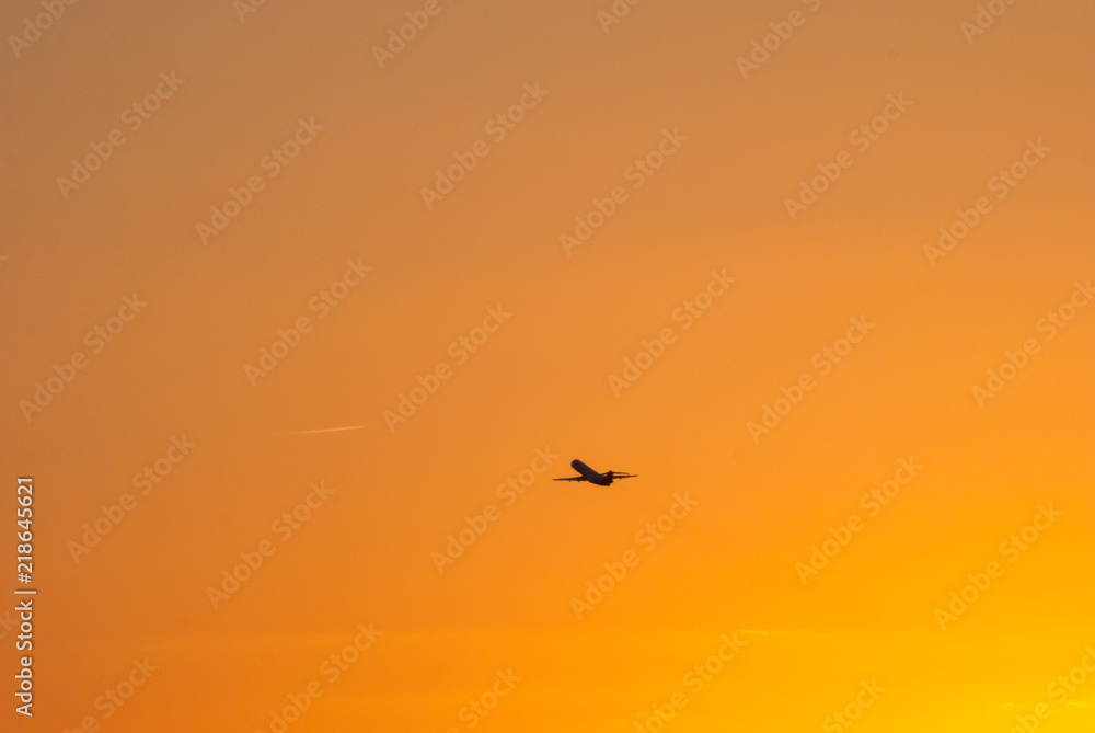 airplane flying in the sunset