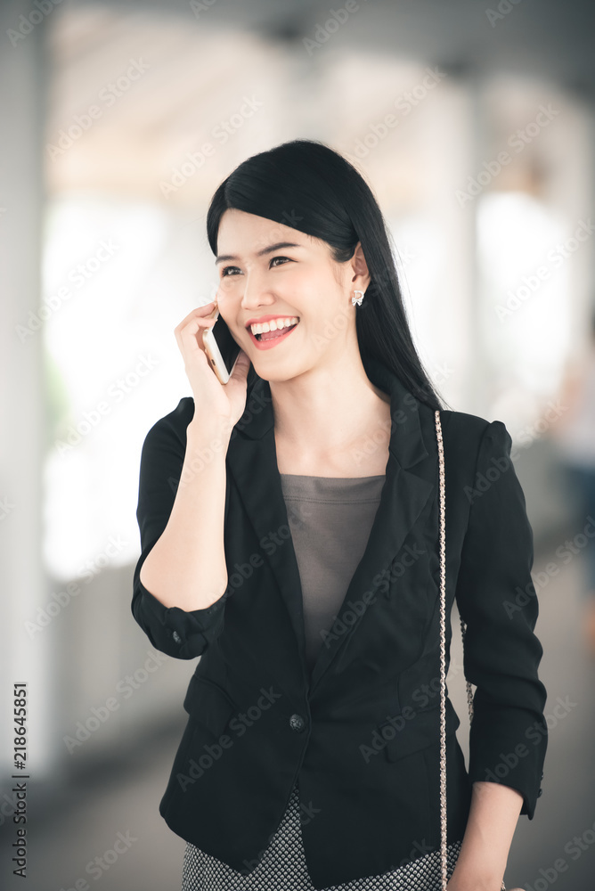 Portrait of Attractive Businesswoman Using Smartphone with Smile on Urban Background - Business and Lifestyle Concept Portrait of Attractive Businesswoman Using Smartphone with Smile on Urban Background - Business and Lifestyle Concept