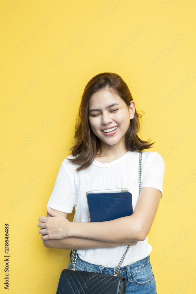 portrait of beautiful university student is smiling on yellow wall background portrait of beautiful university student is smiling on yellow wall background