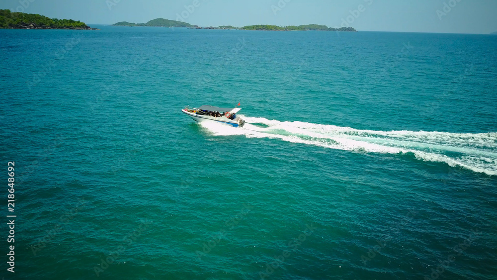 Naklejka premium Ferry at the Gulf of Siam. Aerial view of floating ferry at sunset. Colorful landscape with boat, turquoise sea. Top view from drone of yacht. Seascape with motorboat