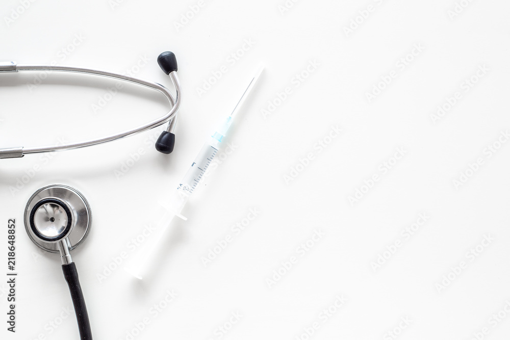 Infuenza vaccine in syringe near stethoscope on white background top view copy space Infuenza vaccine in syringe near stethoscope on white background top view copy space