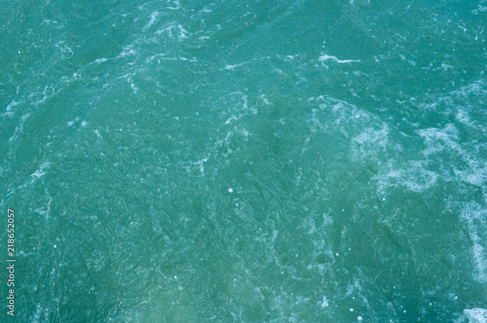 pebble stones on the sea beach, the rolling waves of the sea with foam