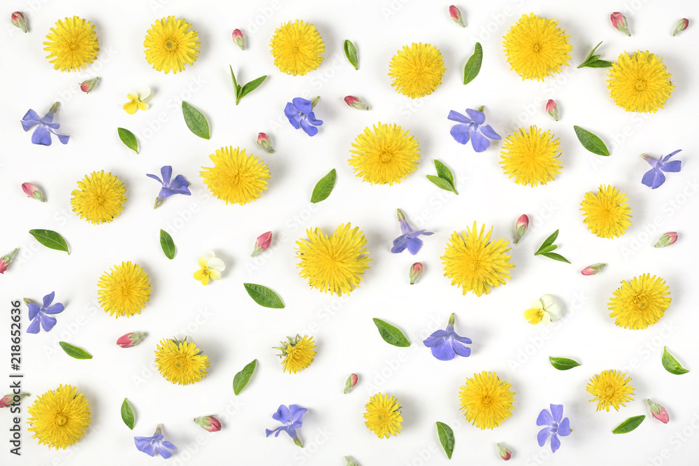Obraz premium Floral pattern made of yellow dandelion, lilac flowers, pink buds and green leaves isolated on white background. Flat lay. Top view.