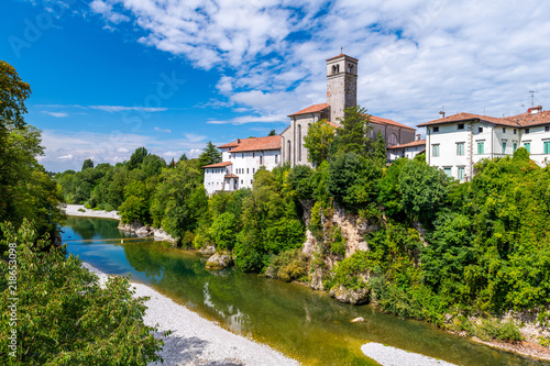 Cividale del Friuli, Italy: View of the old city center with traditional architecture. River Natisone with transparent water. Summer day and blue sky with clouds. photo