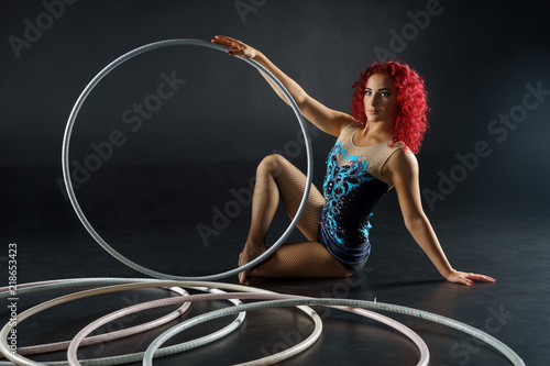 beautiful female red hair circus artist with a hoops