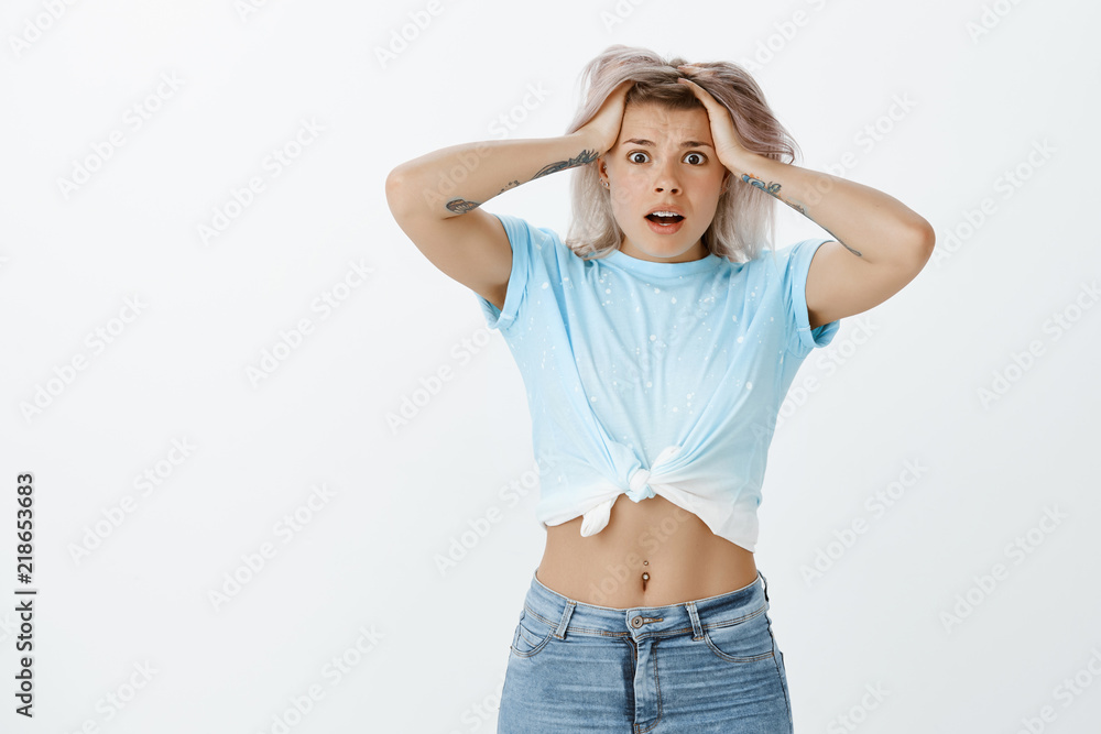 Gosh, what should I do. Portrait of anxious scared attractive woman in stylish outfit, looking terrified, holding hands on hair, dropping jaw and frowning, feeling nervous facing terrible situation Gosh, what should I do. Portrait of anxious scared attractive woman in stylish outfit, looking terrified, holding hands on hair, dropping jaw and frowning, feeling nervous facing terrible situation