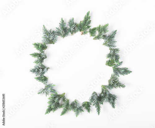 Round frame made of juniper branches isolated on white background. Top view with copy space. Flat lay. Christmas or New year composition.