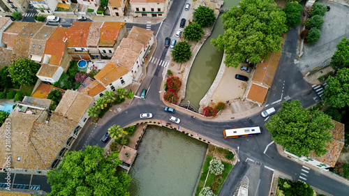 Aerial top view of boats and lock in Canal du Midi, road and bridge from above, Southern France
