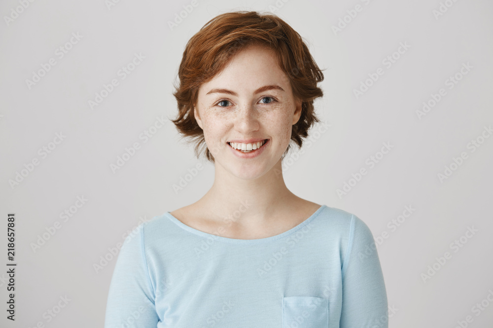 I will be there for you. Studio shot of positive adorable redhead girl with short haircut and freckles smiling and talking with friend, ready to offer help if needed, standing over gray background. I will be there for you. Studio shot of positive adorable redhead girl with short haircut and freckles smiling and talking with friend, ready to offer help if needed, standing over gray background.