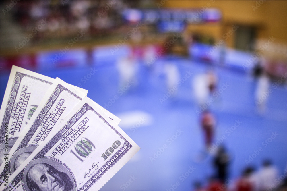 Obraz premium Money dollars on the background of a TV on which show handball, sports betting, money dollars and handball