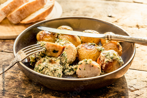 Swedish food - traditional chicken meatballs with cream sauce and new potatoes on a rustic wooden background, top view