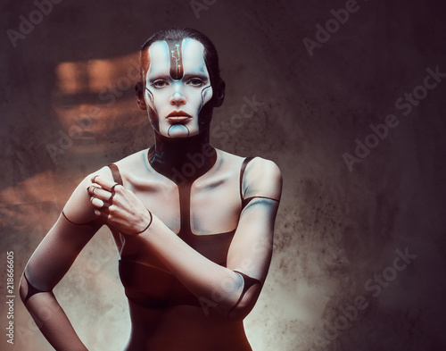 Sensual cyber woman with creative make-up. Technology and future concept. Isolated on a dark textured background.  photo