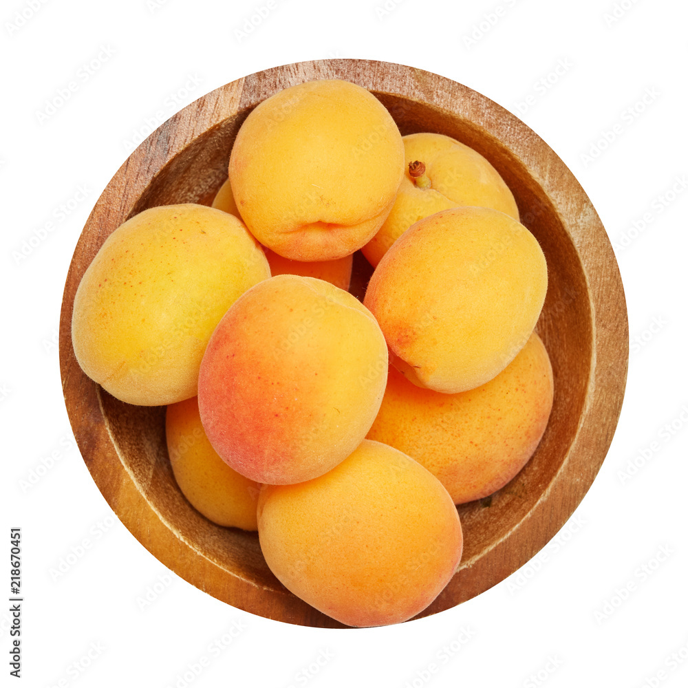 Fresh ripe apricot in wood bowl isolated on white background. Ingredients for cooking. Top view. Fresh ripe apricot in wood bowl isolated on white background. Ingredients for cooking. Top view.