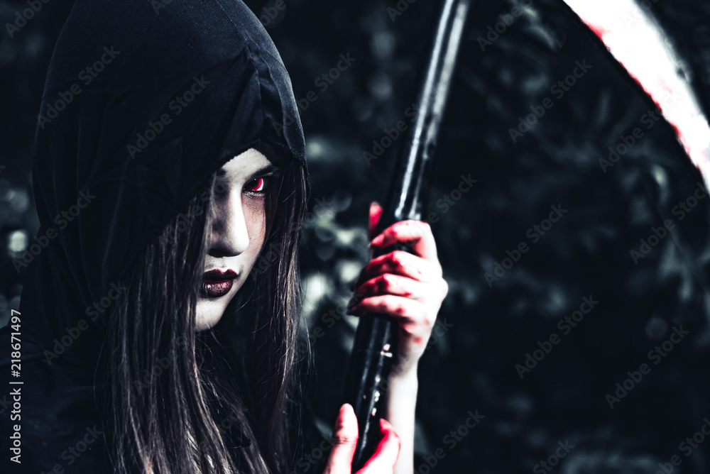 Female demon witch with bloody reaper standing in front of mystery forest  background. Halloween and Religious concept. Demon angel and Satan theme.  foto de Stock | Adobe Stock