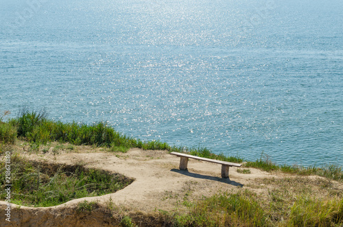 An old wooden bench on a cliff over the sea