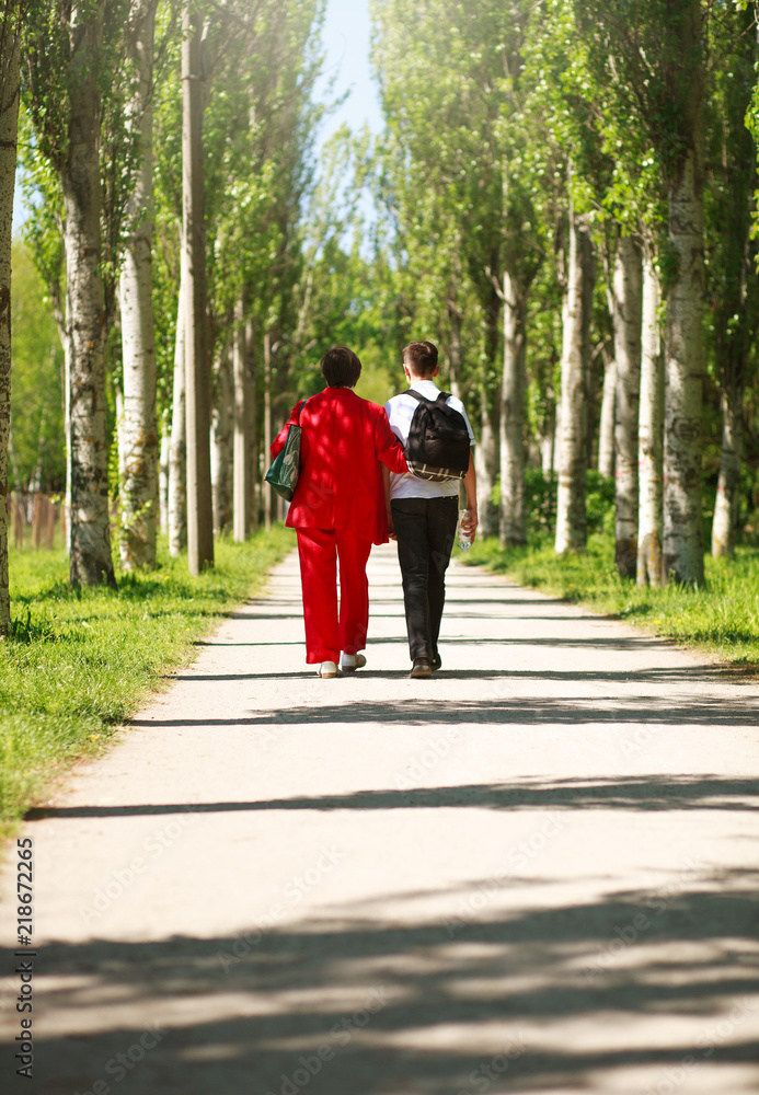 Mother and child walking together in summer city park Mother and child walking together in summer city park