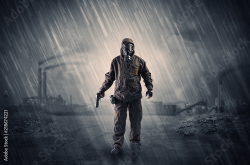 Gas masked survival man coming with arms on his hand in a demolished dark environment 