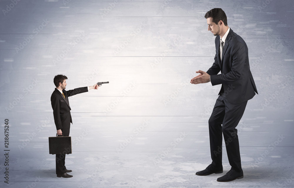 Tiny businessman with gun shooting giant fearful businessman
Tiny businessman with gun shooting giant fearful businessman