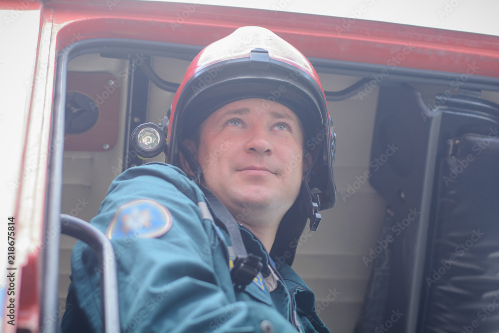 A firefighter in protective clothing and a helmet sits in a cargo rescue vehicle A firefighter in protective clothing and a helmet sits in a cargo rescue vehicle