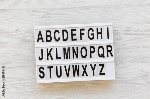 Back to school concept. Letters from A to Z. English alphabet on modern board over white wooden background, top view. From above, flat lay, overhead.