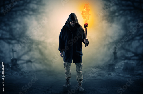 Man with burning flambeau coming from thicket and looking something   © ra2 studio