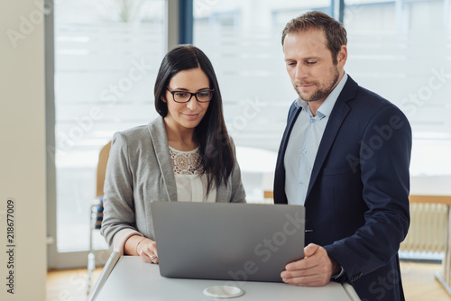 Businessman and woman working on a laptop