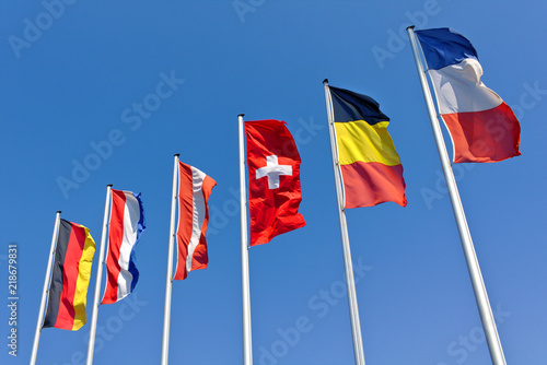 The national flags of Germany, the Netherlands, Austria, Switzerland, Belgium and France flying in front of a blue sky