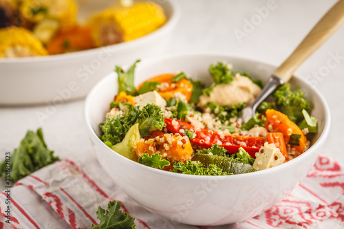 Healthy vegan salad with roasted vegetables, tahini, quinoa and kale. Clean eating concept.