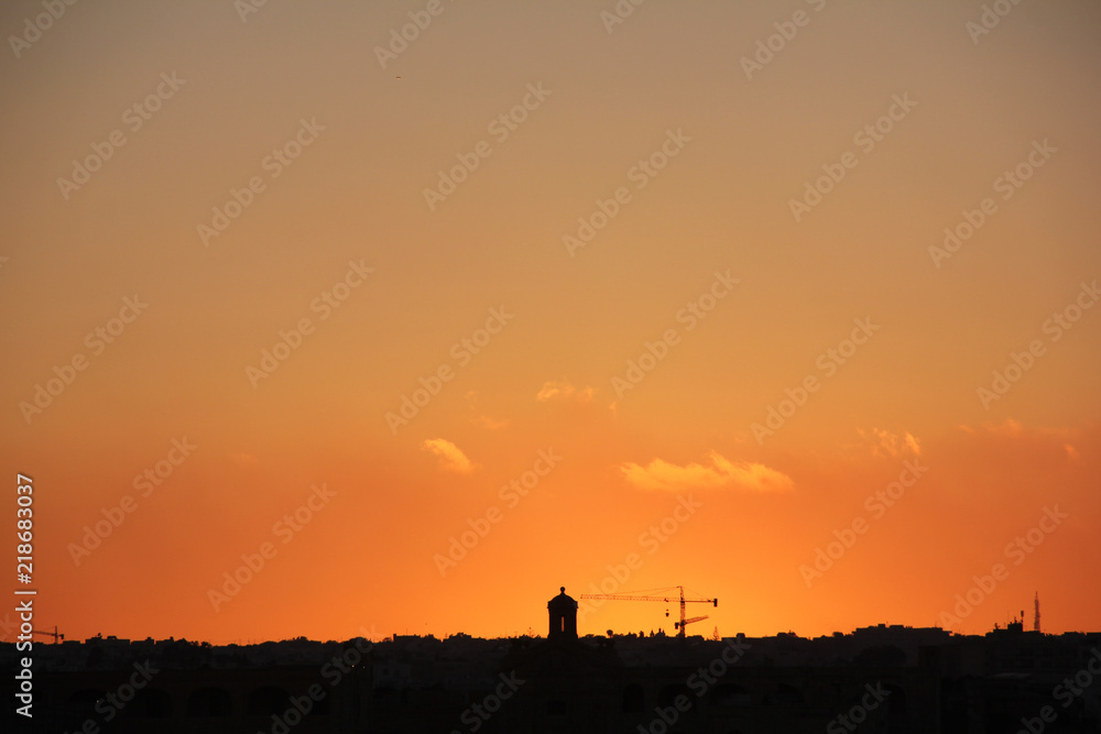 Orange sunset sky above silhouette of city towers Orange sunset sky above silhouette of city towers
