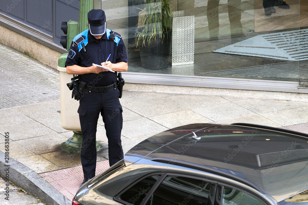 policeman writing fine ticket for car bad parking - obrazy, fototapety, plakaty 