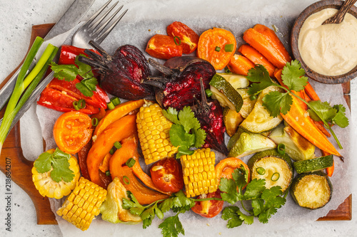 Baked vegetables  pumpkin  beets  carrots  peppers  zucchini and corn on wooden board.