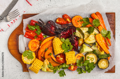 Baked vegetables: pumpkin, beets, carrots, peppers, zucchini and corn on wooden board.
