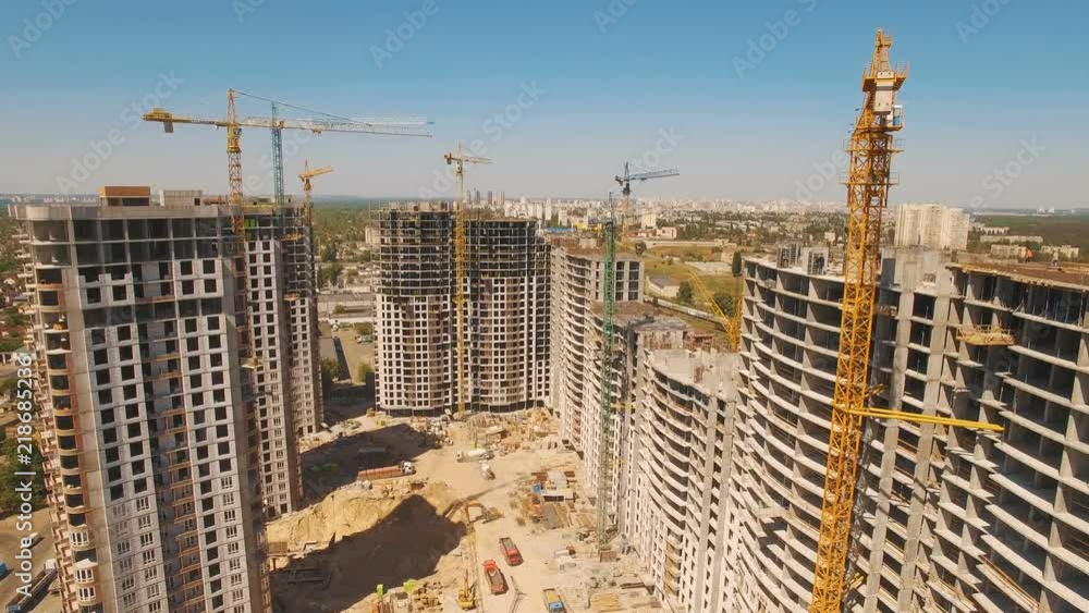 Construction of houses. Drone fly over construction site with tower cranes Construction of houses. Drone fly over construction site with tower cranes