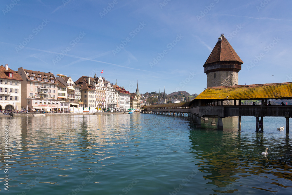 Scenery of riverside of Reuss river , Wooden Chapel Bridge and Water Tower  in the Old Town of Lucerne, Switzerland during sunshine day.