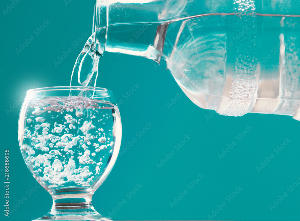 water glass and water bottle with water filling and blue background