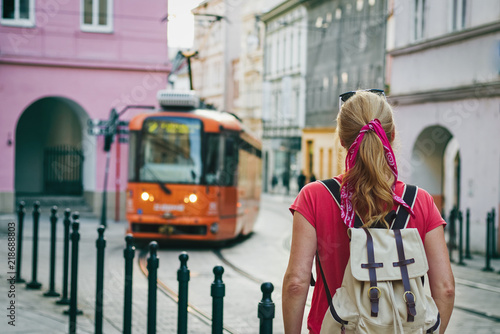 Tourist woman looking at passing tram in ancient city Olomouc, Czech Republic