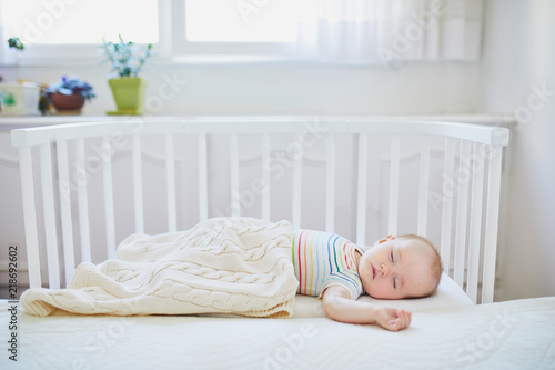 Baby girl sleeping in co-sleeper crib