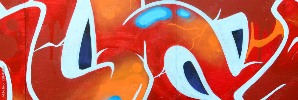 Obraz premium Fragment of graffiti drawings. The old wall decorated with paint stains in the style of street art culture. Colored background texture