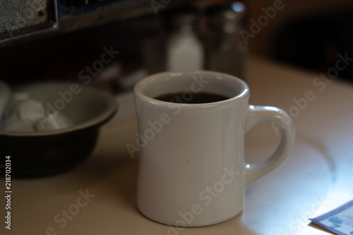 Coffee In A Mug On A Table With Cream In A Booth At A DIner During The Day