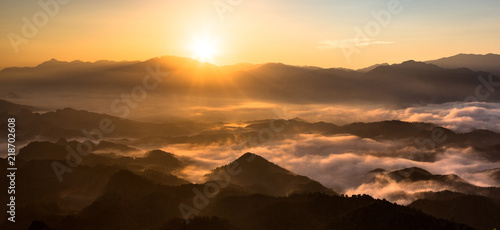 Panoramic view of china mountains - Sunrise, the sea of clouds, mountains and valleys. Warm orange sunrise and rays of sunshine, National forest scenic area in Hunan Province China. Morning fog