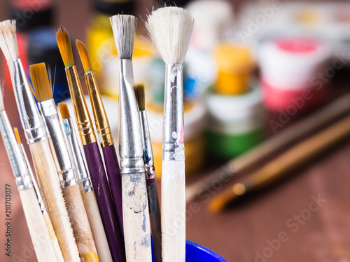 Old painted brushes in the foreground close-up photo