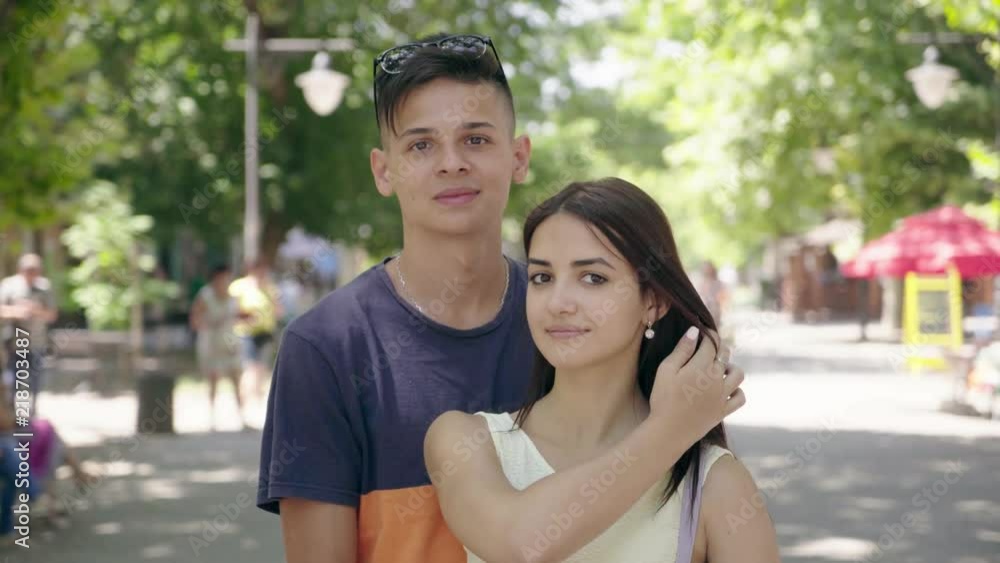 Portrait of a young happy family in love standing and smiling cheery thinking about their future life in a green park alley in summer. Portrait of a young happy family in love standing and smiling cheery thinking about their future life in a green park alley in summer.