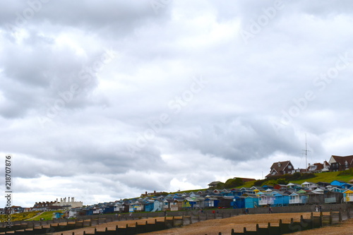 View of the sandy beach and painted wooden beach huts at Whitstable in Kent in south east England. Whitstable, Kent, UK, August, 2018