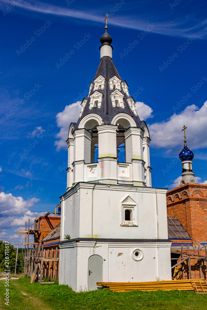 Fototapeta premium Ancient tent belfry of the 17th-century Ilyinsky church in the village of Ilinskoe (Iljinskoe). Zhukovsky district, Kaluzhskiy region, Russia. August 2018