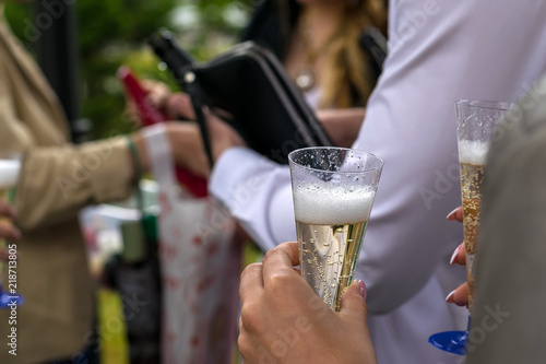 the hand of the man in the white shirt pours champagne on a holiday in the open air