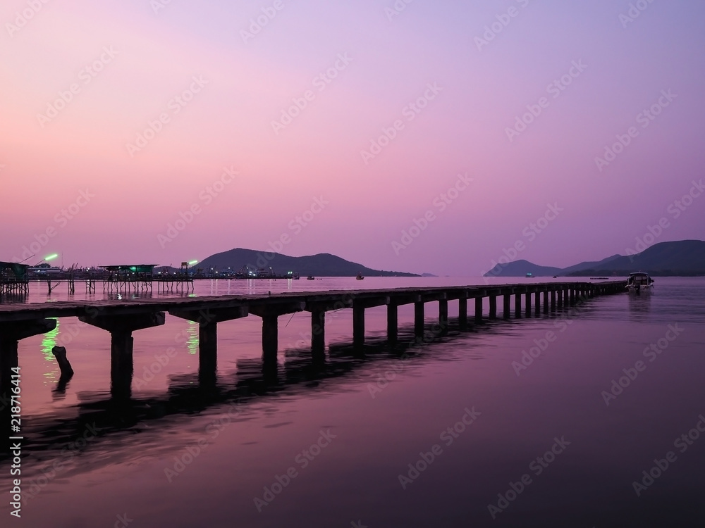 Local pier at sunrise or sunset background in Thailand. Wooden bridge at twilight purple sky.